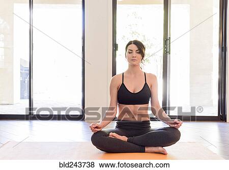 Stock Photo - Caucasian woman performing yoga and meditating. Fotosearch