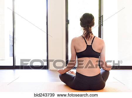 Stock Photo - Caucasian woman performing yoga and meditating. Fotosearch