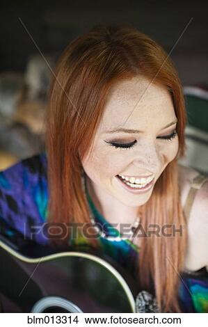 Picture - Caucasian woman playing guitar. Fotosearch