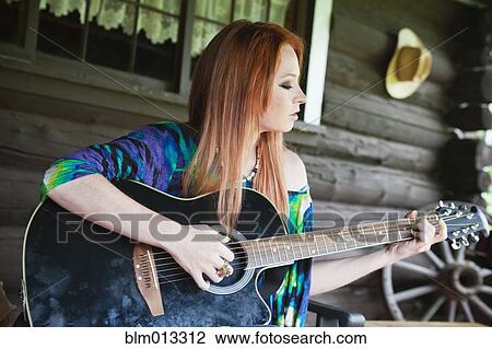 Stock Image - Caucasian woman playing guitar. Fotosearch