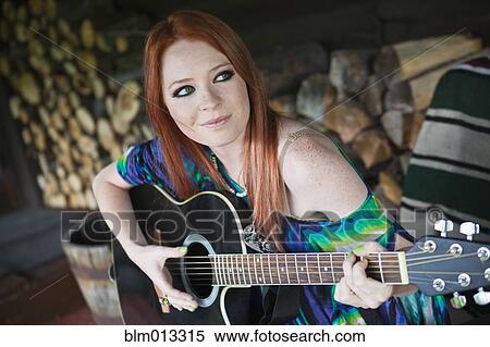 Stock Photography - Caucasian woman playing guitar. Fotosearch