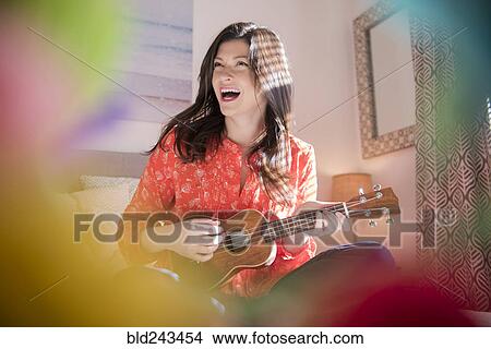 Picture - Caucasian woman playing ukulele. Fotosearch