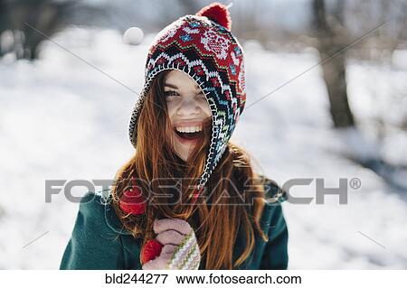 Stock Photo - Caucasian woman playing with hat in winter. Fotosearch
