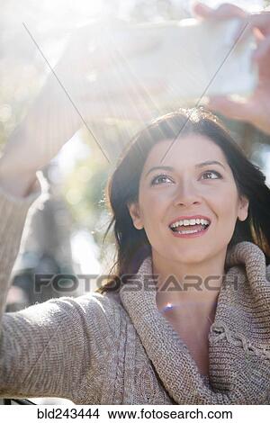Caucasian woman posing for cell phone selfie on sunny day View Large Photo Image Picture - Caucasian woman posing for cell phone selfie on sunny day. Fotosearch