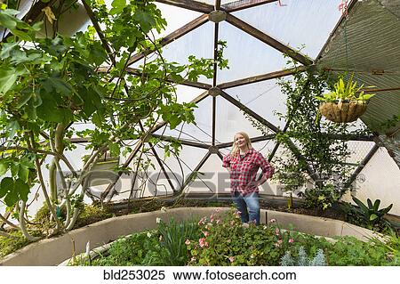 Stock Photography - Caucasian woman posing in greenhouse. Fotosearch