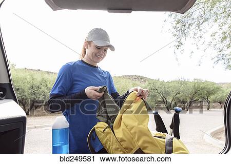 Caucasian woman pulling blanket from backpack in car View Large Photo Image Stock Image - Caucasian woman pulling blanket from backpack in car. Fotosearch