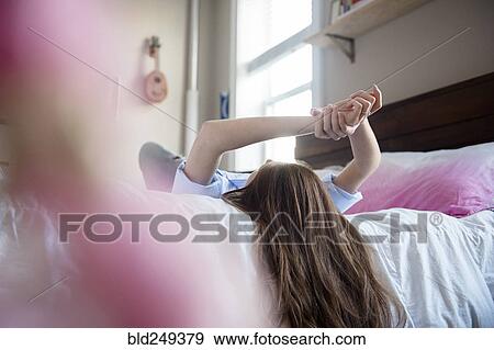 Stock Photo - Caucasian woman relaxing on bed. Fotosearch