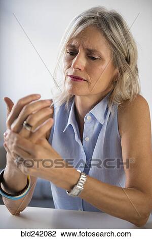 Caucasian woman rubbing hand in pain View Large Photo Image Stock Image - Caucasian woman rubbing hand in pain. Fotosearch