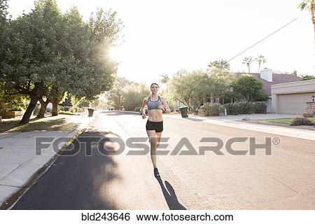 Caucasian woman running in suburban street View Large Photo Image Stock Photograph - Caucasian woman running in suburban street. Fotosearch