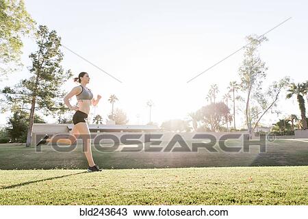 Caucasian woman running on grass in park View Large Photo Image Stock Image - Caucasian woman running on grass in park. Fotosearch