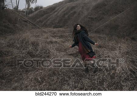 Caucasian woman running on grassy hill View Large Photo Image Stock Image - Caucasian woman running on grassy hill. Fotosearch