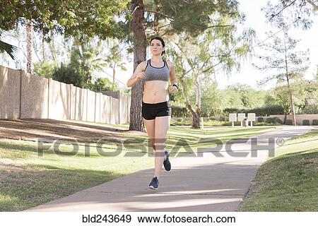 Caucasian woman running on path in park View Large Photo Image Stock Photo - Caucasian woman running on path in park. Fotosearch