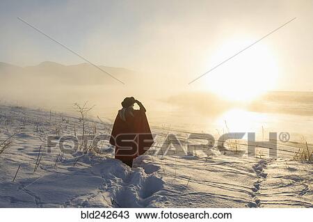 Caucasian woman shielding eyes in winter landscape at sunset View Large Photo Image Stock Image - Caucasian woman shielding eyes in winter landscape at sunset. Fotosearch