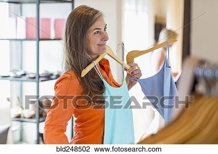 Caucasian woman shopping at clothing store View Large Photo Image Stock Image - Caucasian woman shopping at clothing store. Fotosearch