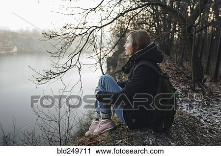 Caucasian woman sitting at the edge of reservoir wearing backpack View Large Photo Image Stock Image - Caucasian woman sitting at the edge of reservoir wearing backpack. Fotosearch