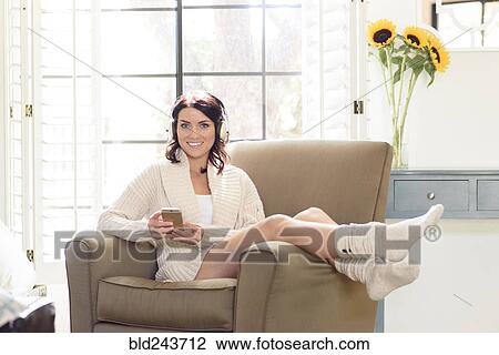 Caucasian woman sitting in armchair texting on cell phone View Large Photo Image Stock Image - Caucasian woman sitting in armchair texting on cell phone. Fotosearch