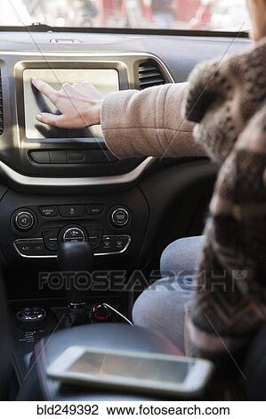 Caucasian woman sitting in car pressing touch screen View Large Photo Image Stock Image - Caucasian woman sitting in car pressing touch screen. Fotosearch