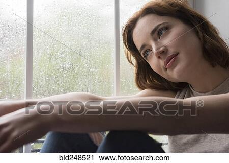 Caucasian woman sitting near rainy window daydreaming View Large Photo Image Stock Image - Caucasian woman sitting near rainy window daydreaming. Fotosearch