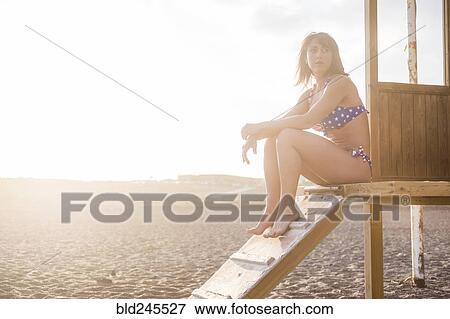 Caucasian woman sitting on cabana at beach View Large Photo Image Stock Photo - Caucasian woman sitting on cabana at beach. Fotosearch