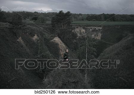 Caucasian woman sitting on hill View Large Photo Image Stock Photograph - Caucasian woman sitting on hill. Fotosearch