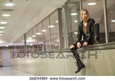Caucasian woman sitting on ledge of window in corridor View Large Photo Image Picture - Caucasian woman sitting on ledge of window in corridor. Fotosearch