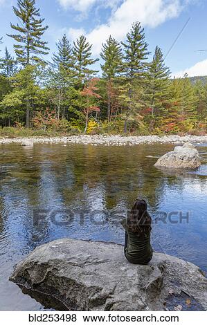 Caucasian woman sitting on rock relaxing near river View Large Photo Image Stock Photo - Caucasian woman sitting on rock relaxing near river. Fotosearch