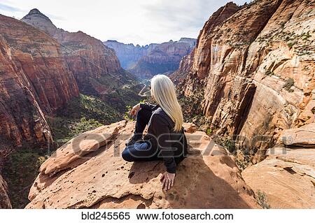 Caucasian woman sitting on rock admiring scenic view of rock formations View Large Photo Image Stock Photography - Caucasian woman sitting on rock admiring scenic view of rock formations. Fotosearch