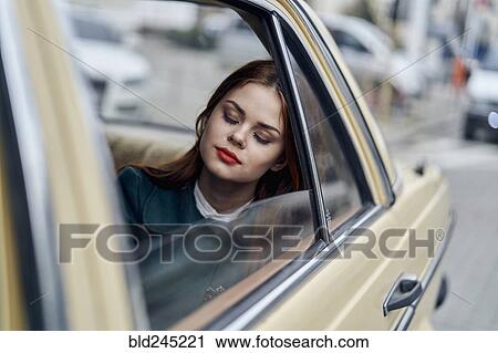 Stock Image - Caucasian woman sleeping in back seat of car. Fotosearch