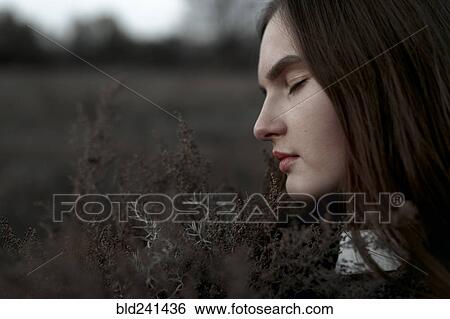 Stock Photograph - Caucasian woman smelling foliage. Fotosearch