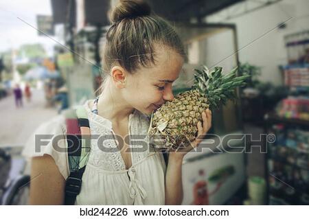 Caucasian woman smelling pineapple at market View Large Photo Image Stock Photograph - Caucasian woman smelling pineapple at market. Fotosearch