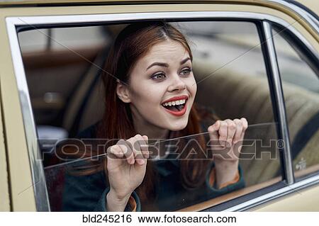 Stock Photograph - Caucasian woman smiling in back seat of car. Fotosearch