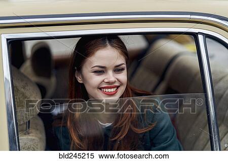 Stock Photography - Caucasian woman smiling in back seat of car. Fotosearch