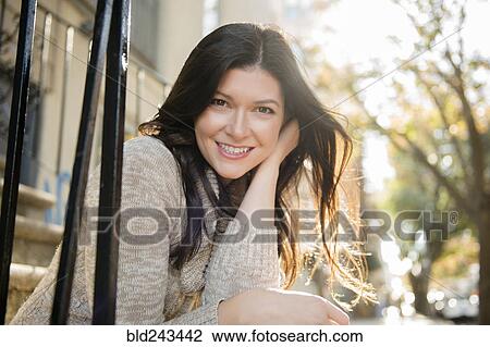 Stock Image - Caucasian woman smiling in city. Fotosearch