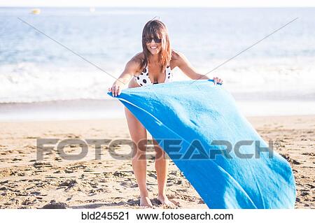 Caucasian woman spreading blanket on beach View Large Photo Image Stock Image - Caucasian woman spreading blanket on beach. Fotosearch