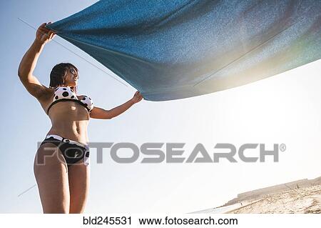 Caucasian woman spreading blanket on beach View Large Photo Image Stock Image - Caucasian woman spreading blanket on beach. Fotosearch