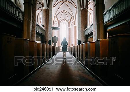 Stock Image - Caucasian woman standing in aisle of church. Fotosearch