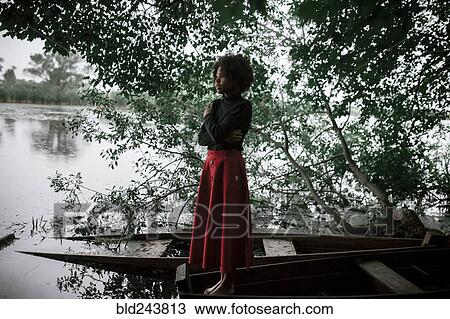 Caucasian woman standing in boat at river View Large Photo Image Stock Image - Caucasian woman standing in boat at river. Fotosearch