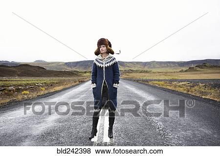 Stock Photo - Caucasian woman standing in middle of road. Fotosearch
