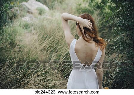 Caucasian woman standing in tall grass with hand in hair View Large Photo Image Stock Image - Caucasian woman standing in tall grass with hand in hair. Fotosearch
