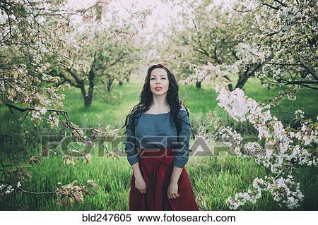 Caucasian woman standing near flowering trees View Large Photo Image Stock Photography - Caucasian woman standing near flowering trees. Fotosearch