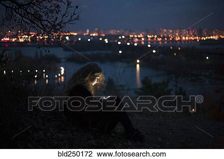 Caucasian woman standing near urban waterfront at night View Large Photo Image Stock Image - Caucasian woman standing near urban waterfront at night. Fotosearch