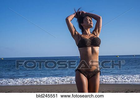Caucasian woman standing on beach with hands in hair View Large Photo Image Stock Image - Caucasian woman standing on beach with hands in hair. Fotosearch