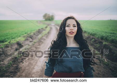Stock Photograph - Caucasian woman standing on dirt path. Fotosearch