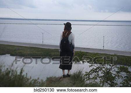 Caucasian woman standing on rock admiring ocean View Large Photo Image Stock Image - Caucasian woman standing on rock admiring ocean. Fotosearch