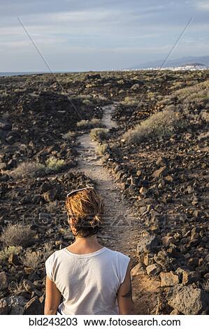 Caucasian woman standing on trail through rocks View Large Photo Image Stock Image - Caucasian woman standing on trail through rocks. Fotosearch