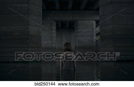 Picture - Caucasian woman standing waist deep in water. Fotosearch