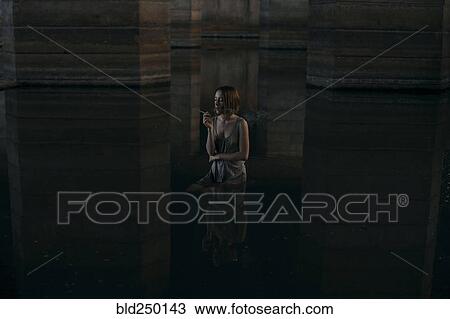 Caucasian woman standing waist deep in water smoking cigarette View Large Photo Image Stock Image - Caucasian woman standing waist deep in water smoking cigarette. Fotosearch