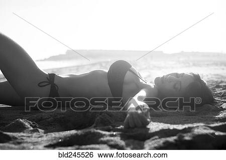 Caucasian woman sunbathing on beach View Large Photo Image Stock Photograph - Caucasian woman sunbathing on beach. Fotosearch