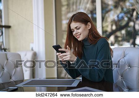 Caucasian woman texting on cell phone at restaurant View Large Photo Image Picture - Caucasian woman texting on cell phone at restaurant. Fotosearch