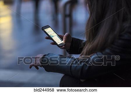 Stock Photo - Caucasian woman texting on cell phone outdoors. Fotosearch